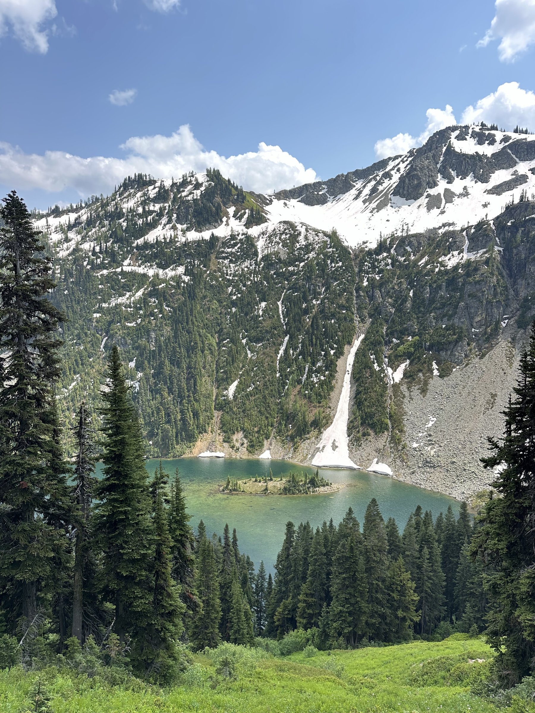 Turquoise mountain lake framed by evergreen forest and snow-dusted peaks
